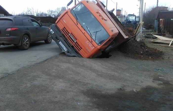 «КамАЗ», приехавший засыпать яму на дороге, провалился в нее