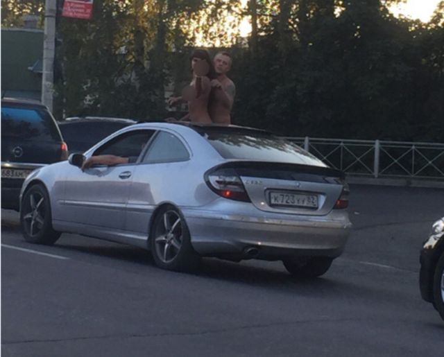 Молодая пара занялась сексом в пробке, высунувшись из люка автомобиля