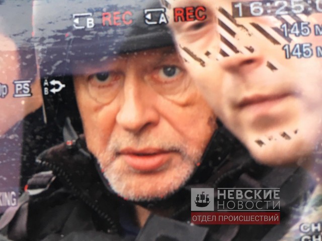 Доцента Олега Соколова выводят со следственного эксперимента из квартиры на Мойке.    