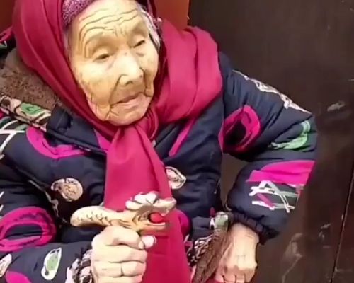 107-летняя китаянка достает из кармана конфету и дает ее своей 84-летней дочери